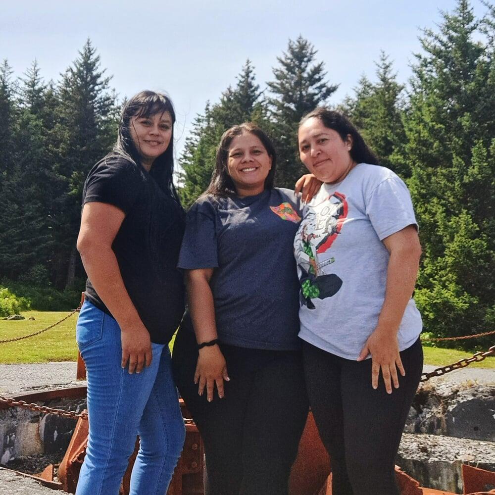 Picture of smiling SBS employees in front of green forest landscape